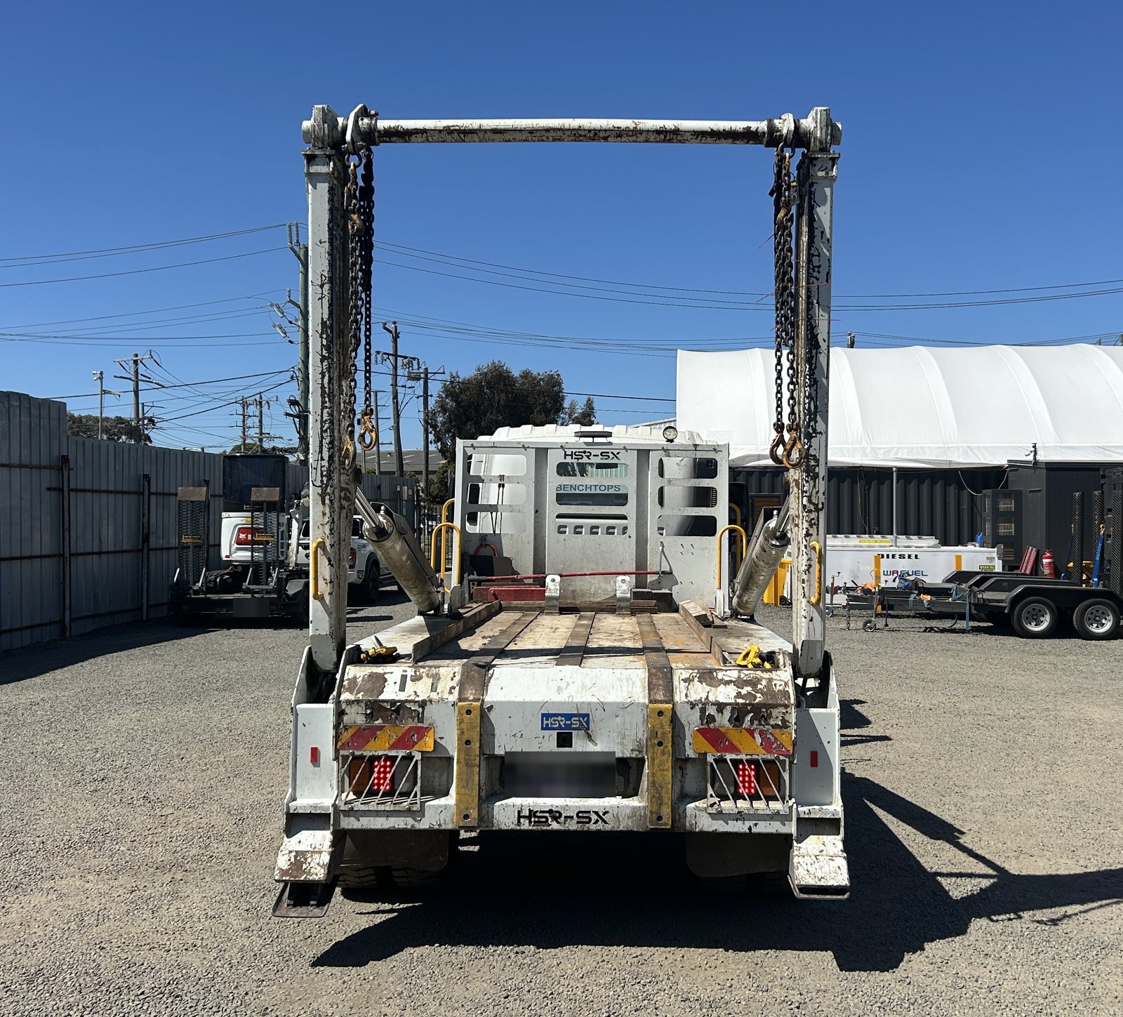 Rear of the small skip truck with lifting arms raised