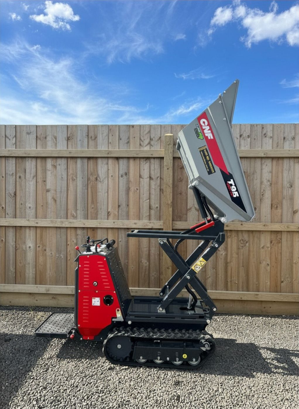 Tracked high-tip mechanical dumper with tray raised